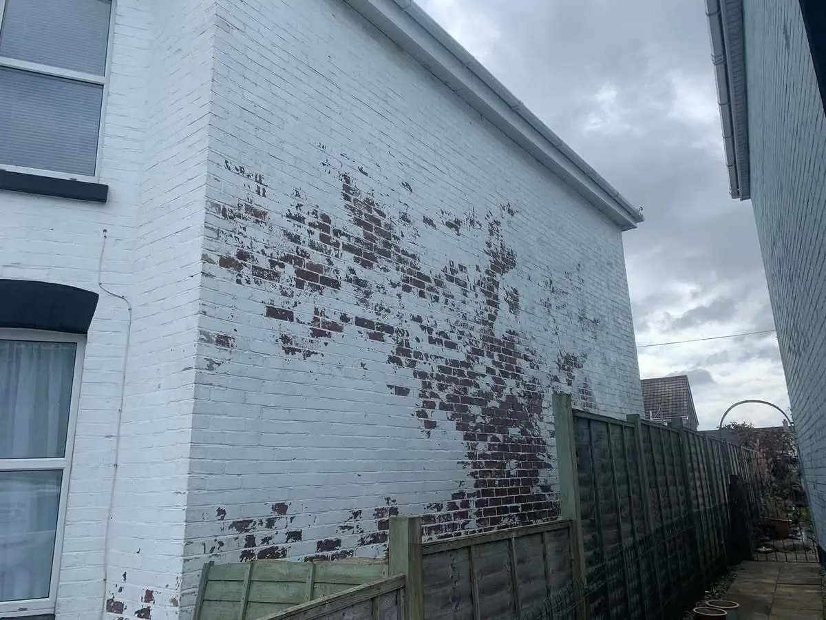 Peeling paint on a brick wall before redecoration in Tintagel